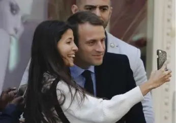  ?? PATRICK KOVARIK/AFP/GETTY IMAGES ?? French president-elect Emmanuel Macron poses with a woman for a selfie on Tuesday in Paris.