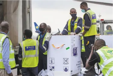  ?? Muhizi Olivier / Associated Press ?? COVID19 vaccines are unloaded in Kigali, Rwanda. More African countries are benefiting from the global COVAX initiative that aims to ensure doses for low and middleinco­me nations.