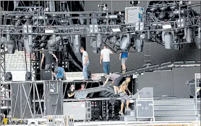  ?? Arkansas Democrat-Gazette/THOMAS METTHE ?? Crews work on setting up the stage for tonight’s Guns N’ Roses concert at War Memorial Stadium in Little Rock. The show requires 15 tractor-trailers of production equipment, 15 tractor-trailers of steel, 100 touring crew members and another 100 local...
