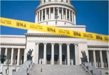  ??  ?? Una cinta de precaución bloquea la calle de entrada del edificio del Capitolio Nacional en La Habana.