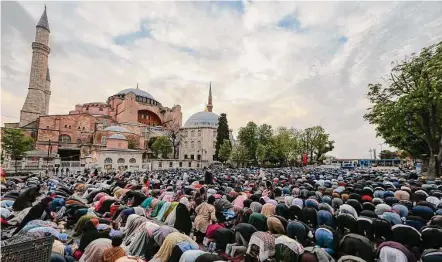  ?? Emrah Gurel / Associated Press ?? Muslims offer prayers during the first day of Eid al-fitr, a three-day feast that marks the end of the holy month of Ramadan, outside the iconic Haghia Sophia Mosque in Istanbul, Turkey.