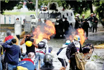  ??  ?? Demonstrat­ors clash with riot security forces while rallying against Maduro’s government in Caracas, Venezuela. — Reuters photo