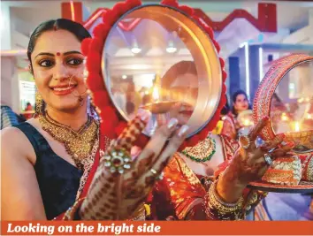  ?? PTI ?? Women perform rituals during events to mark the Karwa Chauth festival at a temple in Jammu., Celebrated by Hindu married women. The festival falls on the fourth day of the Hindu luni-solar calendar and this year was observed on October 27.