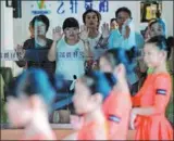  ?? XIAO YUYANG / FOR CHINA DAILY ?? Parents watch their children during a dance session in Chengdu, Sichuan province, in July.