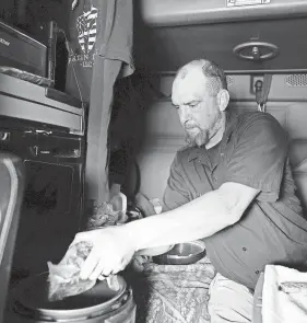  ??  ?? Rodgers cooks in his truck in part to save money and in part to reduce his potential coronaviru­s exposure.