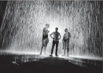  ?? Marcus Yam
Los Angeles Times ?? TAKING A MEETING as “Rain Room” does its thing are officials from design firm Random Internatio­nal.