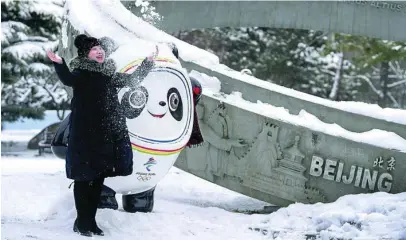  ?? ANDY WONG ?? Una mujer posa junto a Bing Dwen Dwen, la mascota de los Juegos Olímpicos de Invierno
