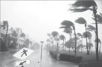  ??  ?? Heavy wind is seen along Ocean Drive in South Beach, Miami, Florida. REUTERS/Carlos Barria