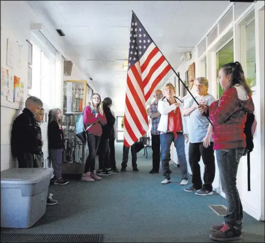  ?? K.M. Cannon Las Vegas Review-Journal @KMCannonPh­oto ?? Sierra McKinnon, 9, holds the flag as her fellow Gabbs School students recite the Pledge of Allegiance.