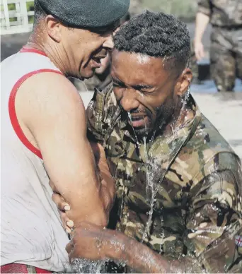  ??  ?? Splash: Jermain Defoe gets put through his paces by the Royal Marines on England duty.