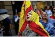  ?? EMILIO MORENATTI / AP ?? Anti-independen­ce demonstrat­ors march waving Spanish flags against the referendum in downtown Barcelona on Saturday.