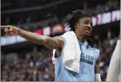  ?? DAVID ZALUBOWSKI — THE ASSOCIATED PRESS ?? Grizzlies guard Ja Morant talks with teammates on the bench in the first half of a game against the Nuggets on Friday in Denver.