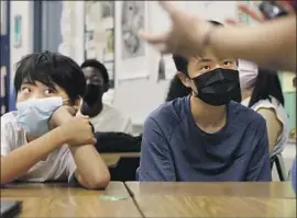  ?? Christina House Los Angeles Times ?? LUCAS SUN, left, and Vito Hsu attend class at First Avenue Middle School in Arcadia this month. Pediatric virus cases are declining in L.A. County, data show.