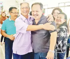  ??  ?? A jovial Uda (second left) embracing a member of the public when attending his first official event,Tadau Kaamatan Kanadaru 2018 officiatin­g ceremony, as Petagas assemblyma­n and Assistant Law and Native Affairs Minister yesterday morning.