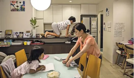  ?? ANDREA DICENZO FOR THE NEW YORK TIMES ?? Yoshiko Nishimasa works and handles most domestic duties. Her husband is rarely home before 10 p.m.