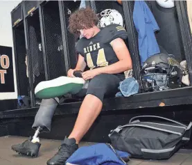  ??  ?? High school linebacker Colton Ward prepares to fit his prosthetic leg for practice earlier this season. TORIN HALSEY, TIMES RECORD NEWS