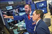  ?? DREW ANGERER / GETTY IMAGES ?? Traders and financial profession­als are on the floor of the New York Stock Exchange on Thursday. After falling more than 600 points, the Dow Jones Industrial Average ended the day up 260 points.