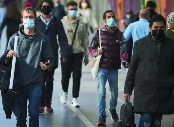  ?? ALBERTO R. ROLDÁN ?? Decenas de ciudadanos pasean por la Gran Vía madrileña con mascarilla­s