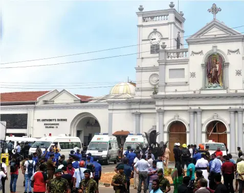  ?? — AFP photo ?? Ambulances are seen outside the church premises with gathered people and security personnel following a blast at the St. Anthony’s Shrine.