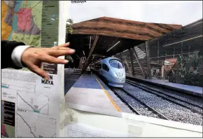  ?? AP/MARCO UGARTE ?? Rogelio Jimenez Pons, director of Fonatur, points to photos of a planned train through the Yucatan Peninsula during an interview in Mexico City last month.