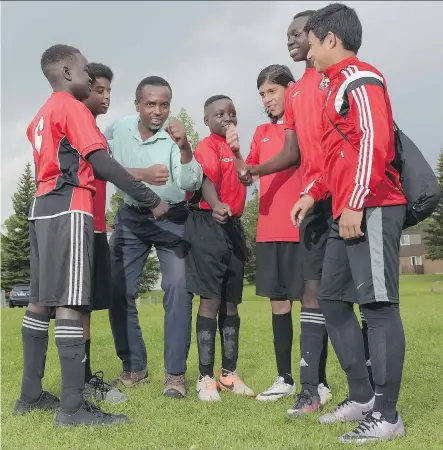  ?? ELIZABETH CAMERON ?? Coach Jean-Claude Munyezamu leads a cheer with players Mayen Dut, Siem Ghebre, Fiston Ngelelo, Jose Moreno, Spiro Kajusa and Moneer Mehalhel from the CalGlen Dynamos U-14 soccer. Munyezamu is organizing the Soccer Without Boundaries annual summer camp.