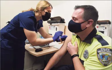  ?? Brian A. Pounds / Hearst Connecticu­t Media ?? West Haven police Officer Doug Bauman gets his Covid-19 vaccine at Griffin Health’s vaccinatio­n center in Shelton on Feb. 16.