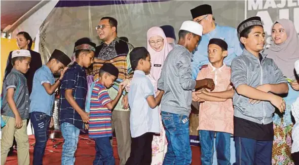  ?? PIC BY ROSLIN MAT TAHIR ?? Deputy Prime Minister Datuk Seri Dr Wan Azizah Wan Ismail giving duit raya to children at Institut Darul Ehsan’s Hari Raya Aidilfitri open house in Shah Alam yesterday.