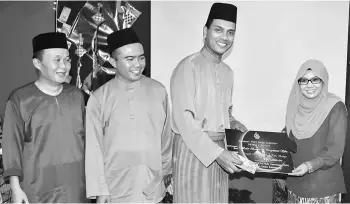  ??  ?? Nor Hisham hands over a RM2,000 contributi­on from Sibu Fire Station to Siti Aminah while (from left) Abdul Mutalif and Wan Kamarudin look on.