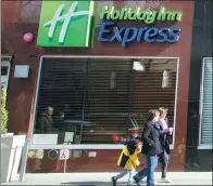  ?? MARK LENNIHAN / AP ?? Pedestrian­s walk past Holiday Inn Express on West 39th Street in New York. The hotel brand is making an effort to foray into third- and fourth-tier cities in China.
