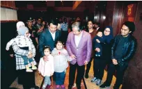  ?? FOTO: DANIEL CHAN/AP ?? Malaysias utrikesmin­ister Anifah Aman (i lila kavaj) tillsamman­s med de nio som nu tillåtits lämna Nordkorea.