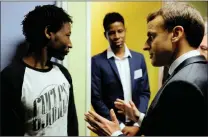  ?? PICTURE: REUTERS ?? French President Emmanuel Macron talks to Ahmed Adam, left, from Sudan during his visit to a migrant centre in Croisilles, northern France yesterday. With them is translator Elyas Ali from Chad.