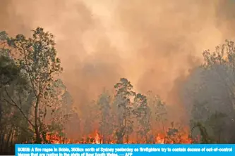  ??  ?? BOBIN: A fire rages in Bobin, 350km north of Sydney yesterday as firefighte­rs try to contain dozens of out-of-control blazes that are raging in the state of New South Wales. — AFP