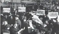  ??  ?? A November 11, 1918, National Archives photo of a crowd in Times Square holding up copies of newspapers with a headline about the signing of the Armistice to end World War I.