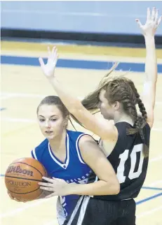  ?? PHOTOS BY JULIE JOCSAK/POSTMEDIA NEWS ?? Jacobi Oskam of the Port Colborne Bears peeks around Isabella Favero of the Lakeshore Gators during the Tribune Girls Basketball Tournament at Port Colborne High School on Thursday.