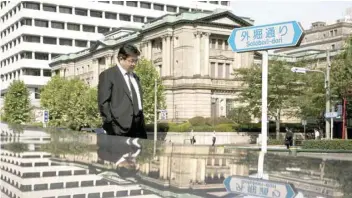  ?? — Reuters ?? A man walks past the Bank of Japan (BoJ) building in Tokyo, Japan.