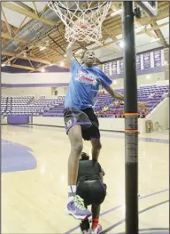  ?? News-Times/ Michael Orrell ?? Up and over: El Dorado's Rickeya Martin leaps over her teammate Shannon O'Guinn to attempt a dunk in the slam dunk contest during the El Dorado Lady Wildcat Team Basketball Camp at the Wildcat Arena Tuesday. Martin placed second in the contest that was...