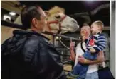  ??  ?? Ringling Bros boss clown Sandor Eke, center, holds his 2year-old son Michael up to pet a camel before performing in a show.