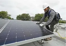  ?? AP FILE PHOTO/BEN MARGOT ?? Gen Nashimoto installs solar panels in at new solar farm. Origis Energy plans to build a new solar farm in Mississipp­i to help power Facebook’s data centers through TVA’s Green Invest program.