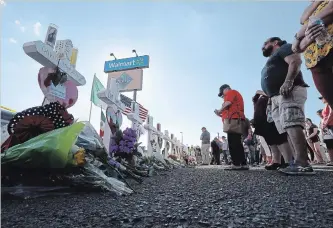  ?? JIM WILSON NYT ?? Mourners visit a makeshift memorial outside the Walmart in El Paso, Texas, days after a gunman opened fire inside the store, killing 22 and wounding more than two dozen others.