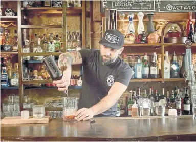  ??  ?? Manny Ferreira behind the bar at Mezcal, in a photo taken from a YMCA video posted on the restaurant’s website.