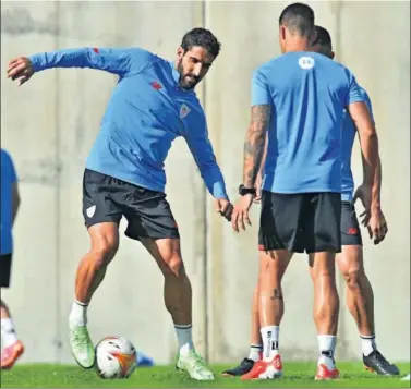  ??  ?? Raúl García toca el balón en la sesión de ayer en Lezama, con Dani García a su lado.