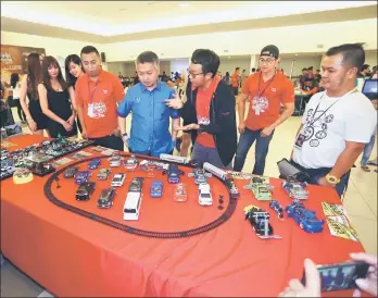  ??  ?? Snowdan (fourth right) takes a look at the miniature cars on display at one of the booths at the carnival.