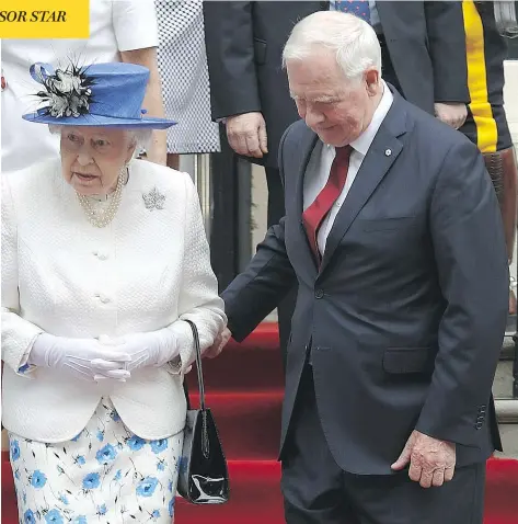  ?? TIM P. WHITBY/GETTY IMAGES ?? Gov. Gen. David Johnston takes the elbow of Queen Elizabeth at Canada House in London on Wednesday. Johnston says he was “certainly conscious of the protocol” of not touching the Queen but said he was concerned about a “stumble.” The Queen, in royal...