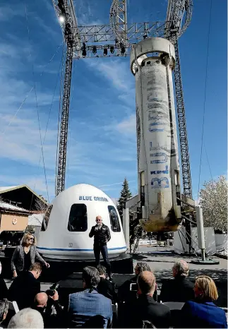  ??  ?? Amazon and Blue Origin founder Jeff Bezos addresses the media about the New Shepard rocket booster and crew capsule mockup.