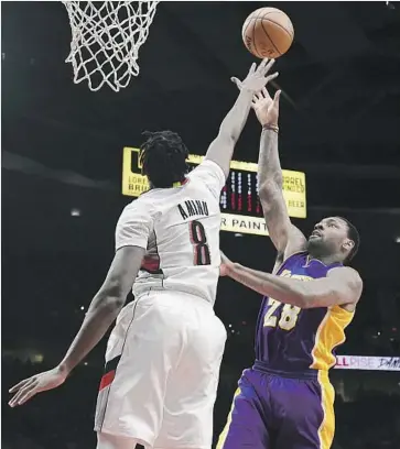  ?? Steve Dykes Associated Press ?? TARIK BLACK of the Lakers puts up a shot against Al-Farouq Aminu of the Trail Blazers in the first half. Black had four points and six rebounds in the Lakers’ seven-point loss.