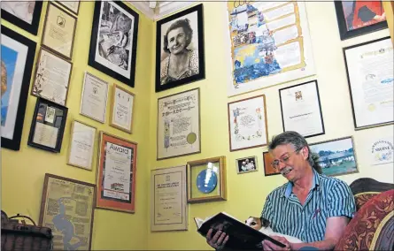  ?? Picture: ANDREW STONE ?? RESCUED ARTEFACTS: Collector Jeff Sansom and his dog, Tina, sit beneath a display of historical documents relating to Marjorie Courtney-Latimer at the Thomas River historical village