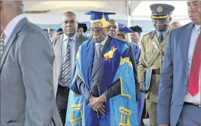  ?? AP PHOTO ?? Zimbabwe’s President Robert Mugabe, center, leaves after presiding over a student graduation ceremony at Zimbabwe Open University on the outskirts of Harare, Zimbabwe Friday. Mugabe is making his first public appearance since the military put him under...