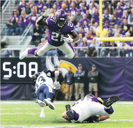  ?? ADAM BETTCHER/GETTY IMAGES ?? Jerick McKinnon of the Minnesota Vikings leaps over defender Nickell Robey-Coleman of the Los Angeles Rams in the first quarter at U.S. Bank Stadium in Minneapoli­s, Minn., on Sunday. “We got humbled today by a very good team,” said Rams coach Sean McVay.