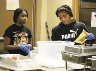  ?? Brodie Johnson • Times-Herald ?? Volunteers with the St. Francis County Food Pantry turn out each holiday to prepare a meal for members of the community who may be in need. The meals are delivered to shut-ins across the area by first responders. Others are allowed to stop by the Pantry to pick up a meal. Victory Williams, left, and Corvion Holmes work to organize meals on Friday at the Pantry.