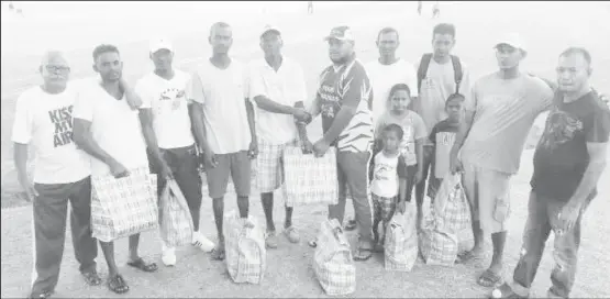  ??  ?? Shan Satar (in the Young Warriors Cricket Club uniform) hands over the hampers to the recipients.